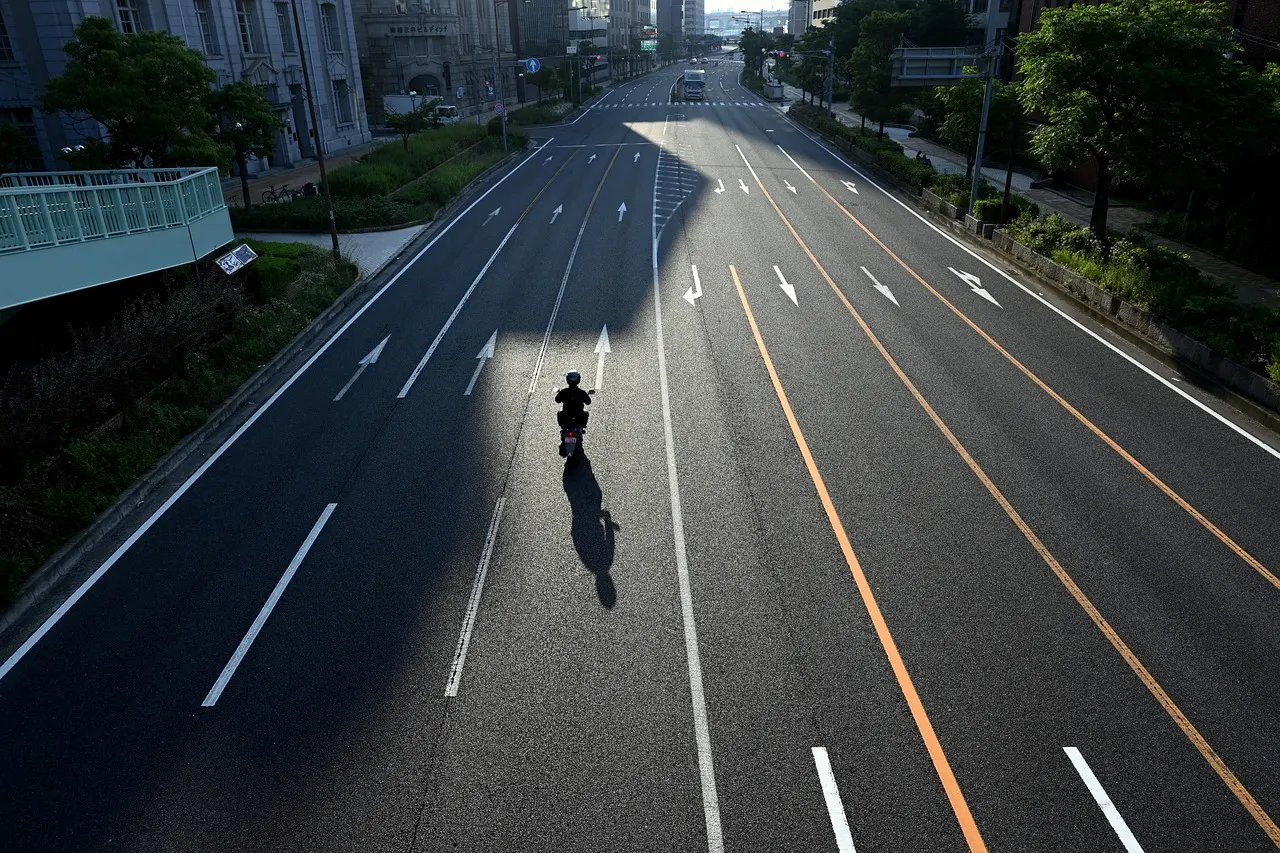 Motard seul sur une large route vide
